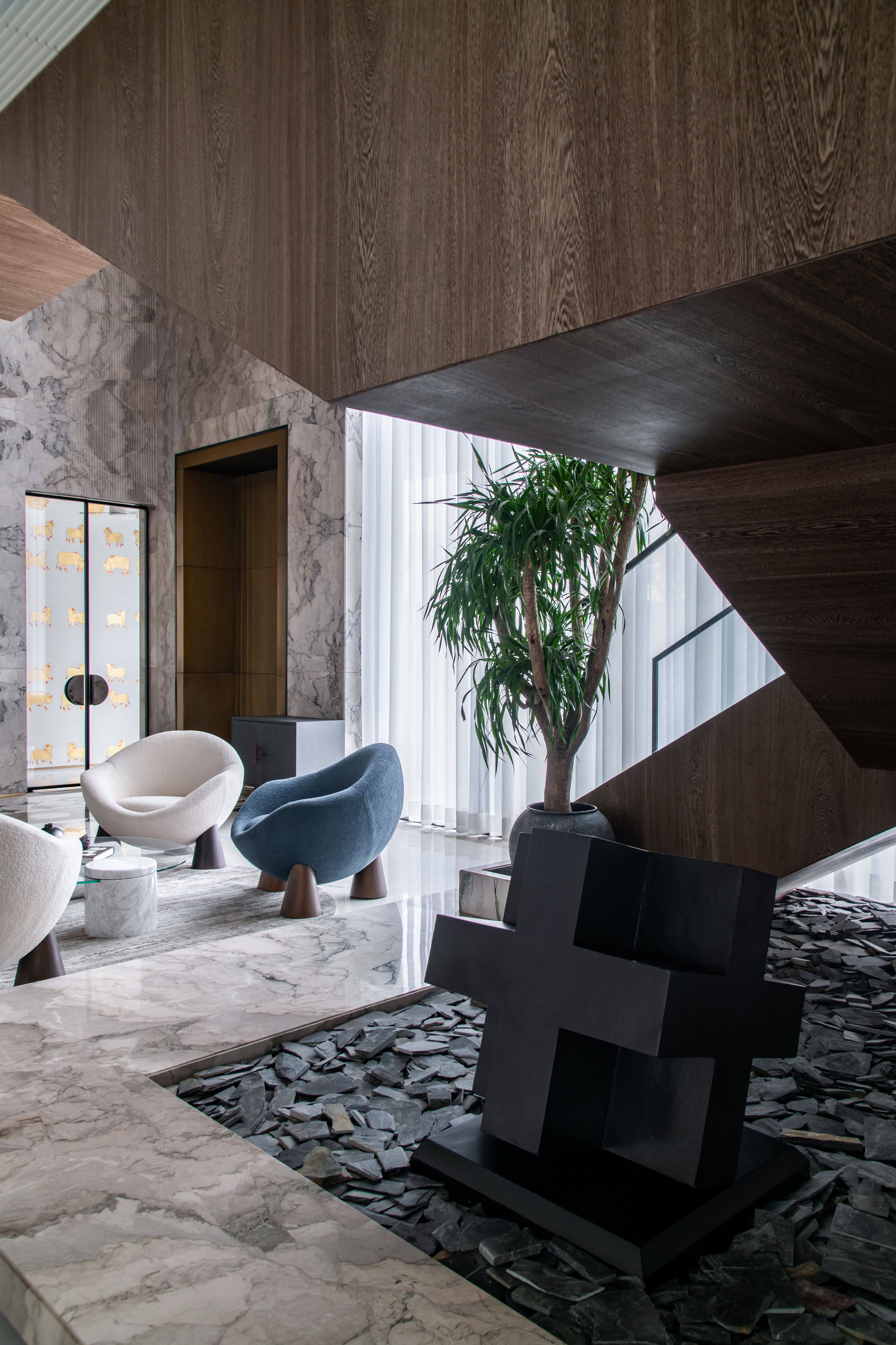 Formal dining room with crystal chandeliers, sculptural mirror and mirrored table base